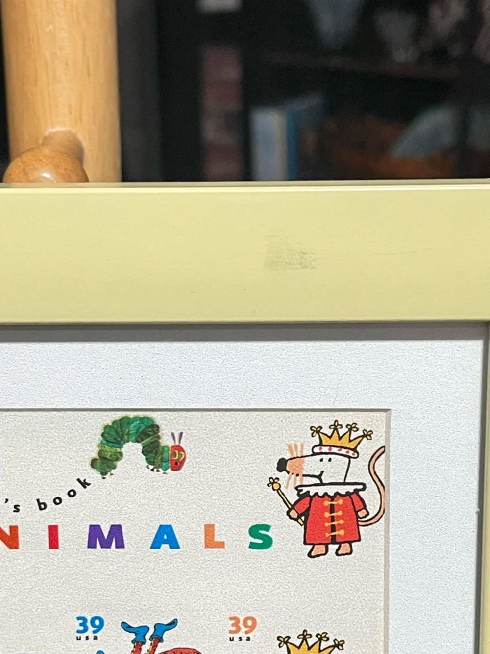 Framed postage stamps of children’s books. Frame soft yellow